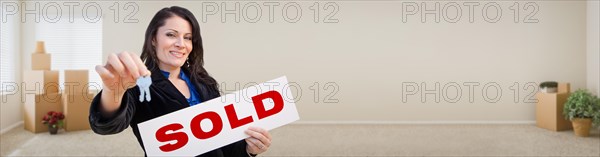 Banner of hispanic woman inside room with boxes holding house keys and sold for sale real estate sign