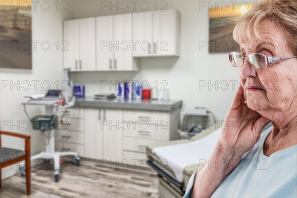 Worried senior adult woman waiting in doctor office