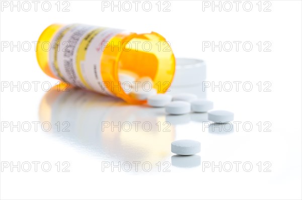 Non-Proprietary medicine prescription bottle and spilled pills isolated on a white background