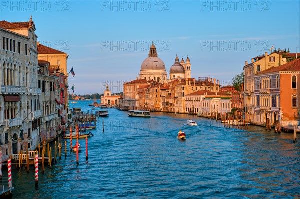 Panorama of Venice Grand Canal with gondola boats and Santa Maria della Salute church on sunset from Ponte dell'Accademia bridge. Venice
