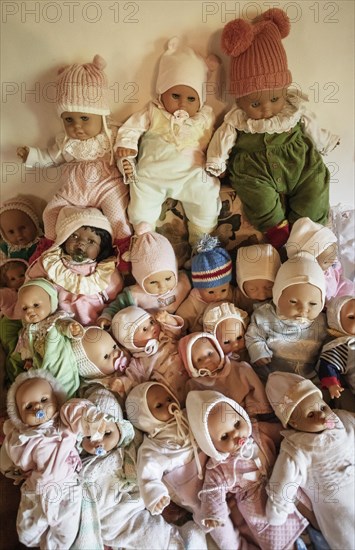 Various decorative dolls and baby dolls lying together