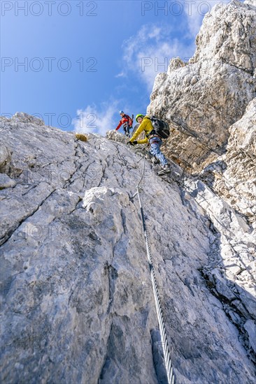 Climber on a via ferrata on a steep rock face