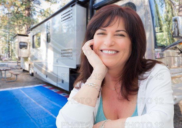 Attractive middle aged woman outdoor portrait in front of class A RV
