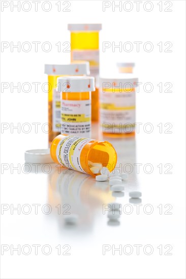 Non-Proprietary medicine prescription bottles and spilled pills isolated on a white background