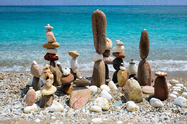 Concept of balance and harmony. Stones pebbles stacks on the beach coast of the blue sea in the nature. Meditative art of stone stacking