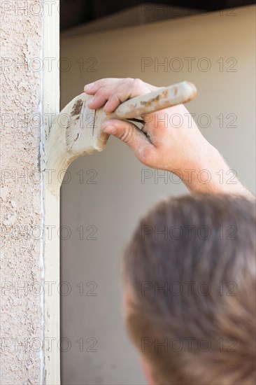 Professional painter cutting in with A brush to paint house door frame