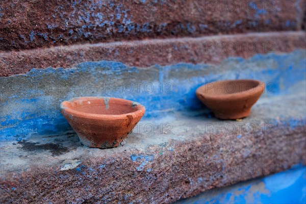 Oil Lamp Pooja Diya Lamp on blue house wall in street of Jodhpur