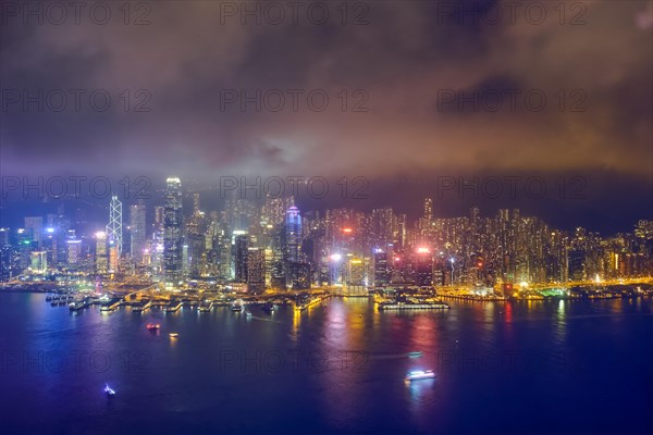 Aerial view of illuminated Hong Kong skyline cityscape downtown skyscrapers over Victoria Harbour in the evening. Hong Kong