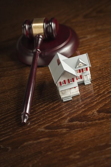 Gavel and small model house on wooden table