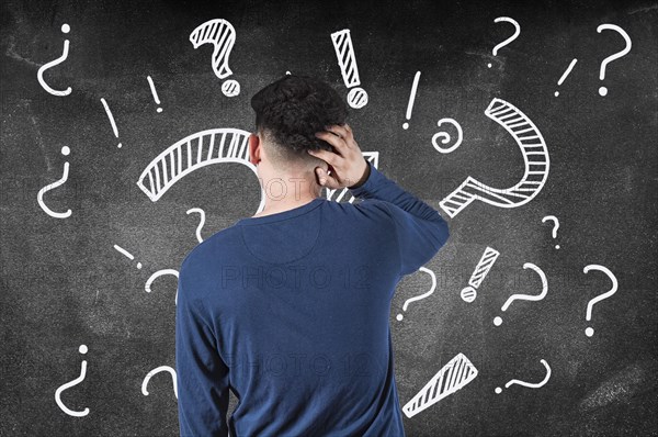 Puzzled man from back of a blackboard