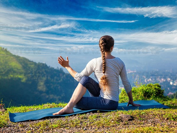 Sporty fit woman practices yoga asana Parivrtta Marichyasana