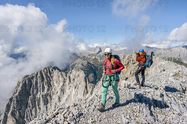 Hiker with climbing helmet on a steep rocky ridge