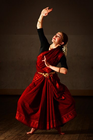 Young woman in sary dancing classical traditional indian dance Bharat Natyam