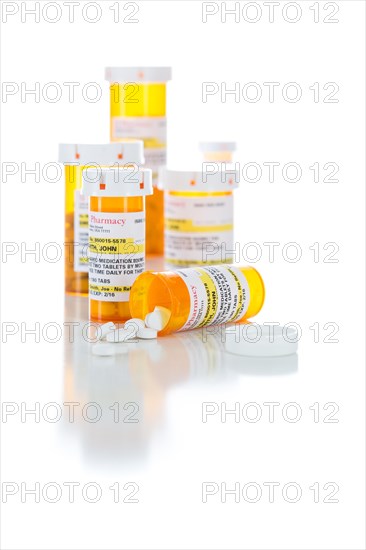 Non-Proprietary medicine prescription bottles and spilled pills isolated on a white background