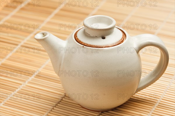 Chinese teapot on bamboo mat close up photo