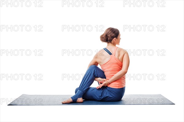 Beautiful sporty fit woman practices yoga asana Ardha matsyendrasana