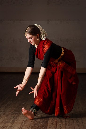 Young woman in sary dancing classical traditional indian dance Bharat Natyam