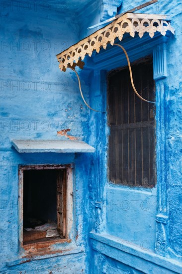 Windows in blue house facade in streets of of Jodhpur