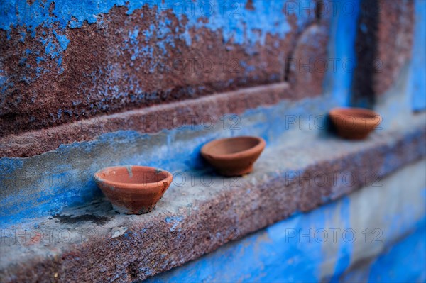 Oil Lamp Pooja Diya Lamp on blue house wall in street of Jodhpur