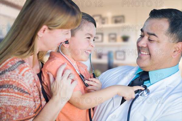 Young boy and mother visiting with hispanic doctor in office