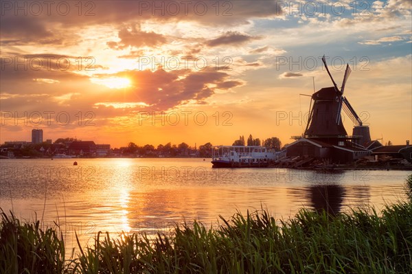 Windmills at famous tourist site Zaanse Schans in Holland on sunset with dramatic sky Zaandam