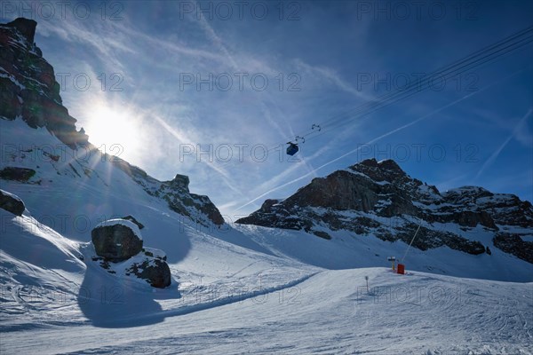 View of a ski resort piste with people skiing in Dolomites in Italy with cable car ski lift. Ski area Arabba. Arabba