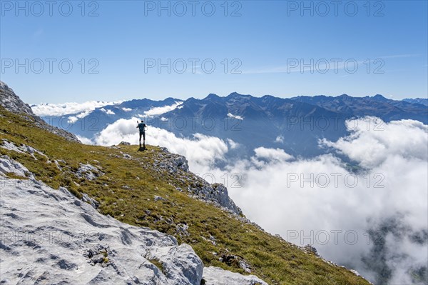 Hiker with climbing helmet on a steep rocky ridge