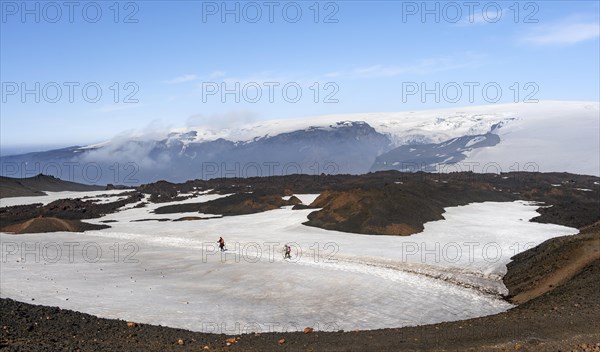 Two hikers on a hiking trail through a snow field