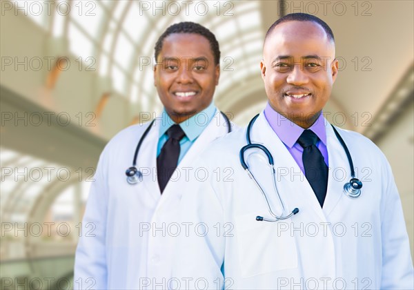 Two handsome african american male doctors inside hospital office