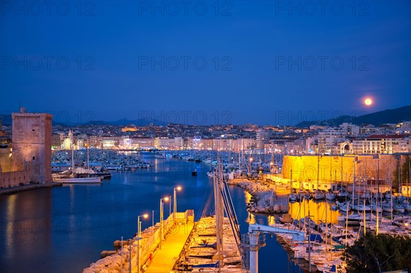 Marseille Old Port and Fort Saint-Jean illumintaed in night with moon