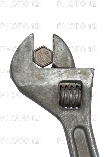 Old adjustable spanner with bolt isolated on white background