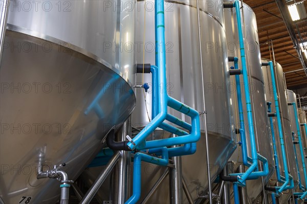 Large beer brewery fermentation tanks in warehouse