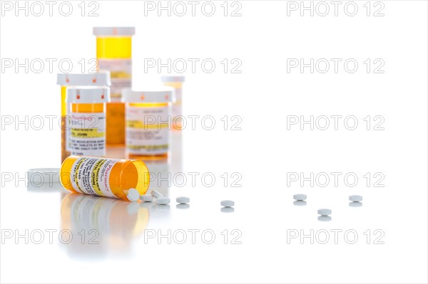 Non-Proprietary medicine prescription bottles and spilled pills isolated on a white background