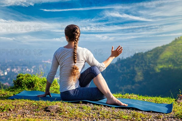 Sporty fit woman practices yoga asana Parivrtta Marichyasana