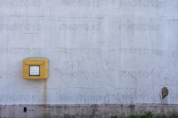 Yellow Deutsche Post letterbox on white wall