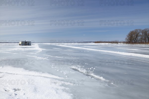 Fishing hut on a wide and frozen riverscape