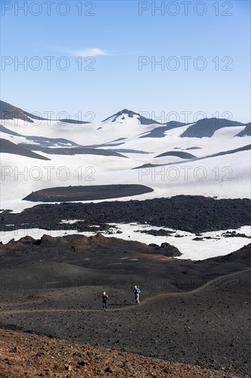 Two hikers on trail through lava sand
