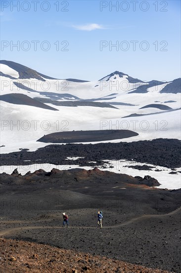 Two hikers on trail through lava sand