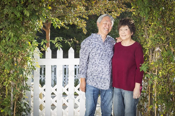 Attractive happy chinese couple enjoying their house outside