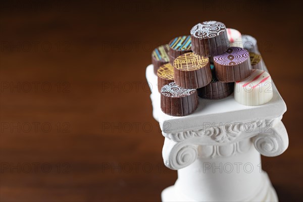 Stack of fine artisan chocolates stacked on white pillar column