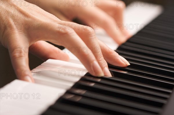 Woman's fingers on digital piano keys