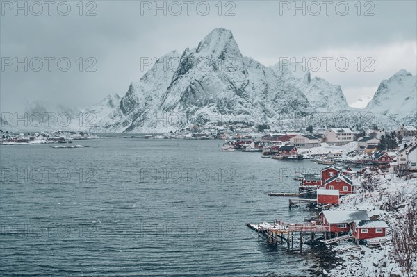 Reine fishing village on Lofoten islands with red rorbu houses in winter with snow. Norway