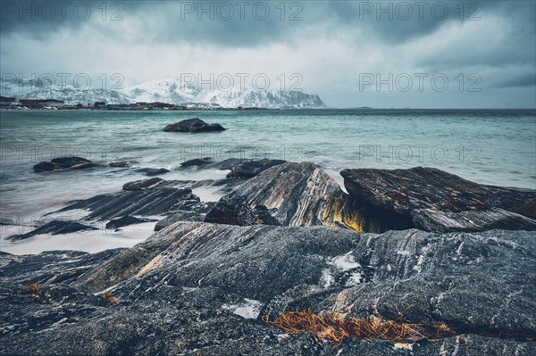 Waves of Norwegian sea on rocky beach of fjord. Ramberg beach