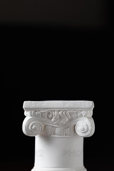 White ionic design column on dark background