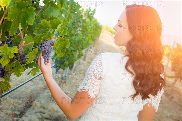 Beautiful young adult woman enjoying A walk in the grape vineyard