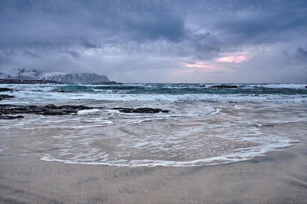 Beach of Norwegian sea on rocky coast in fjord on sunset. Skagsanden beach