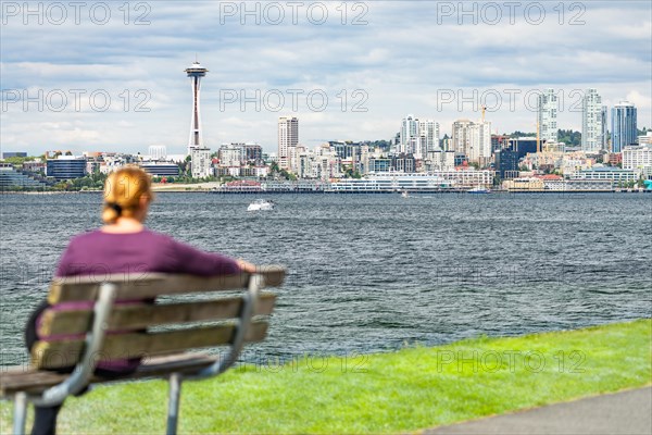 Woman sitting on bench looking at the seattle