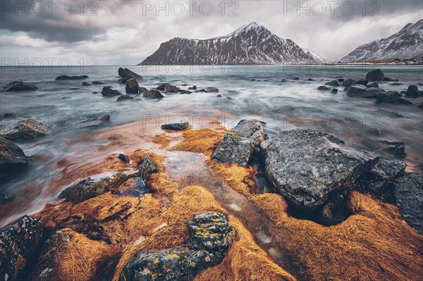 Rocky coast of fjord of Norwegian sea in winter with snow. Skagsanden beach