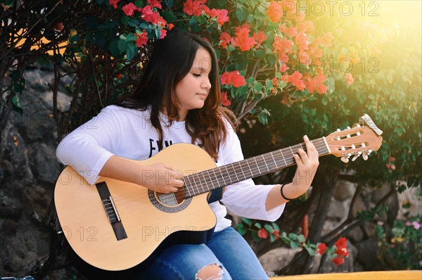 Portrait of a smiling girl playing guitar