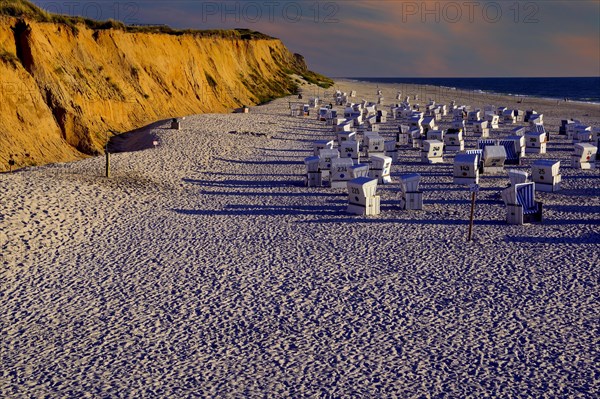 Beach and beach chairs at the red cliff in the evening